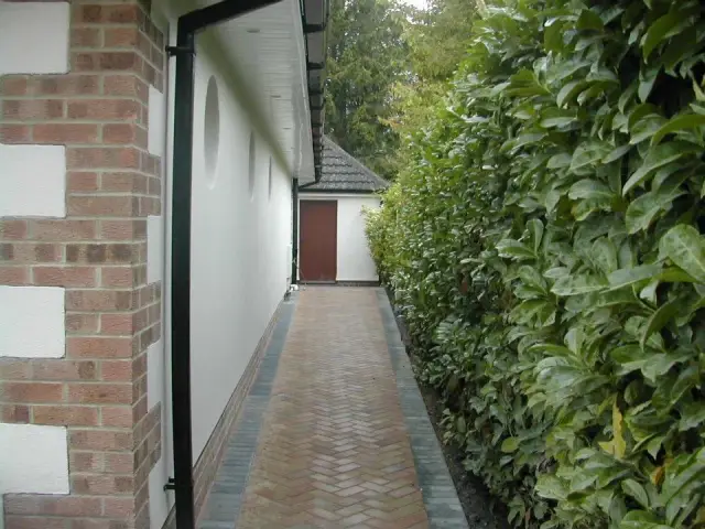 Side passage with brick paving beside extension
