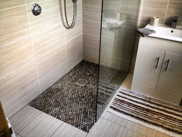 Walk-in shower with mosaic tiled floor