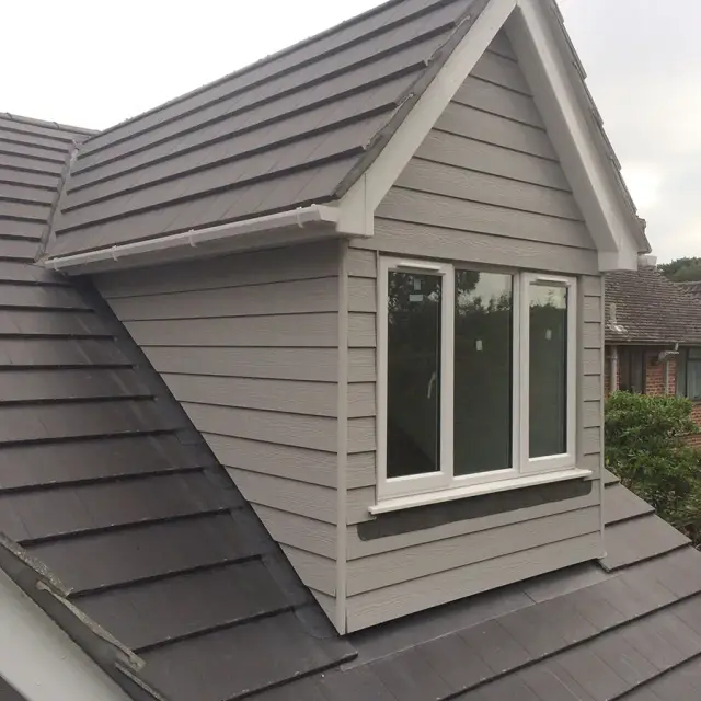 Grey cladded dormer window on tiled roof