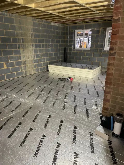 A ground floor room in the extension with insulation boards laid on the floor