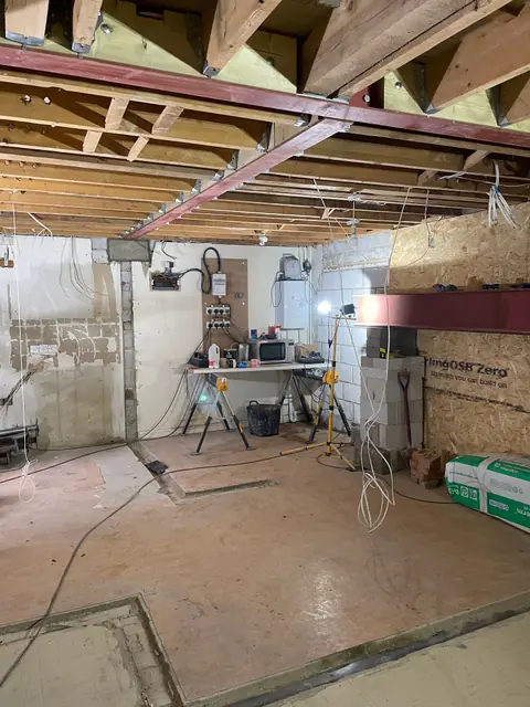 An opened up ground floor room with new steel beams across the ceiling