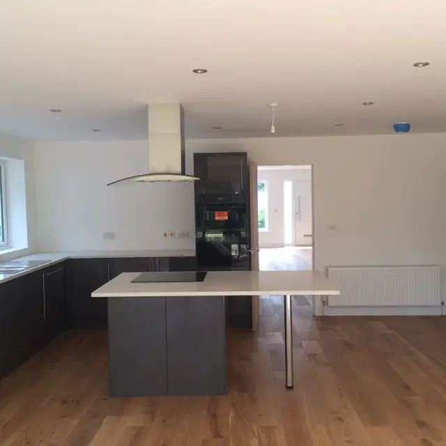 Grey kitchen island with extractor hood above