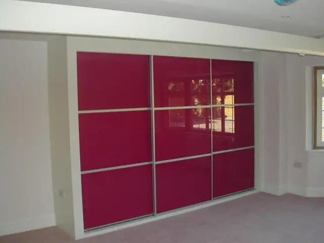 Fitted wardrobe with high-gloss red sliding doors