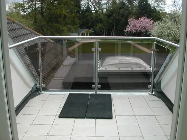 Glass balustrade balcony overlooking rooftop terrace