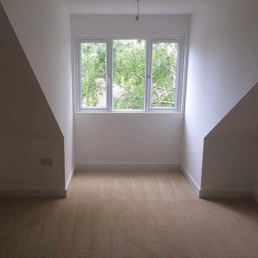 Bright empty loft room with large window