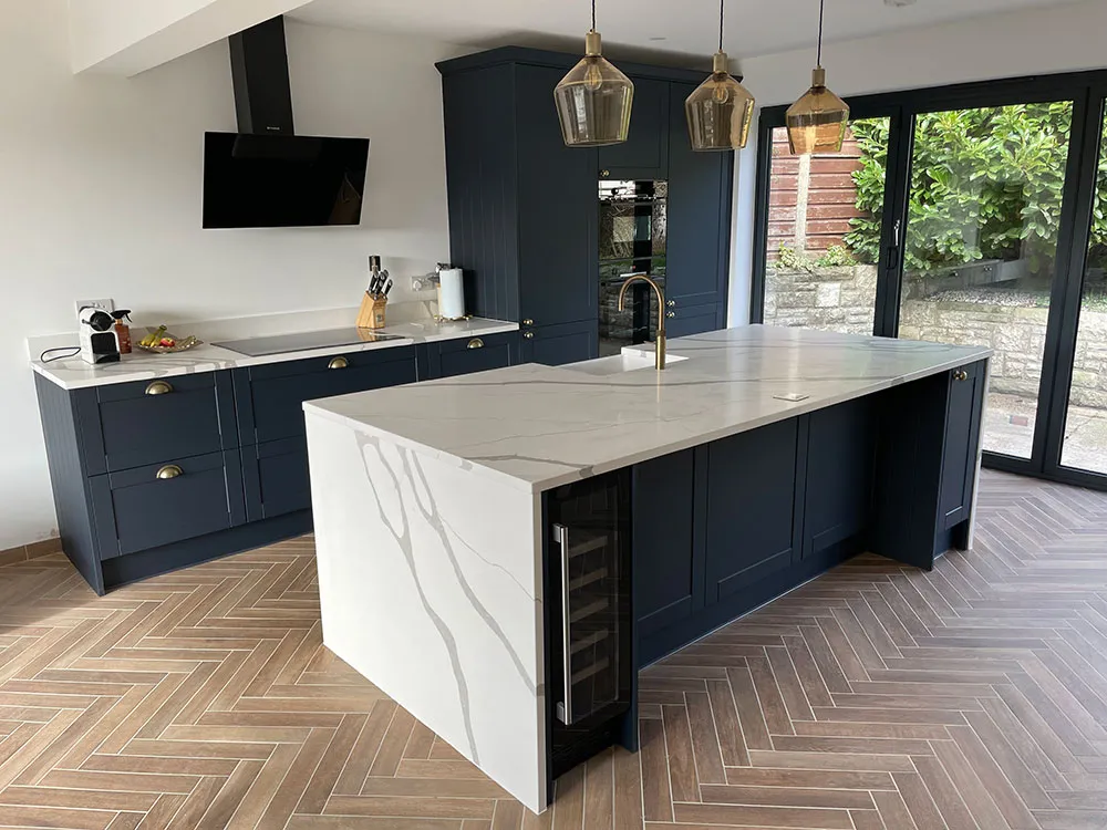 Navy kitchen island with marble worktop and pendants