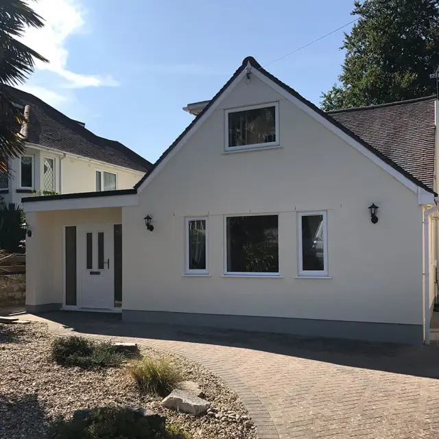 Rendered chalet bungalow with block paved drive