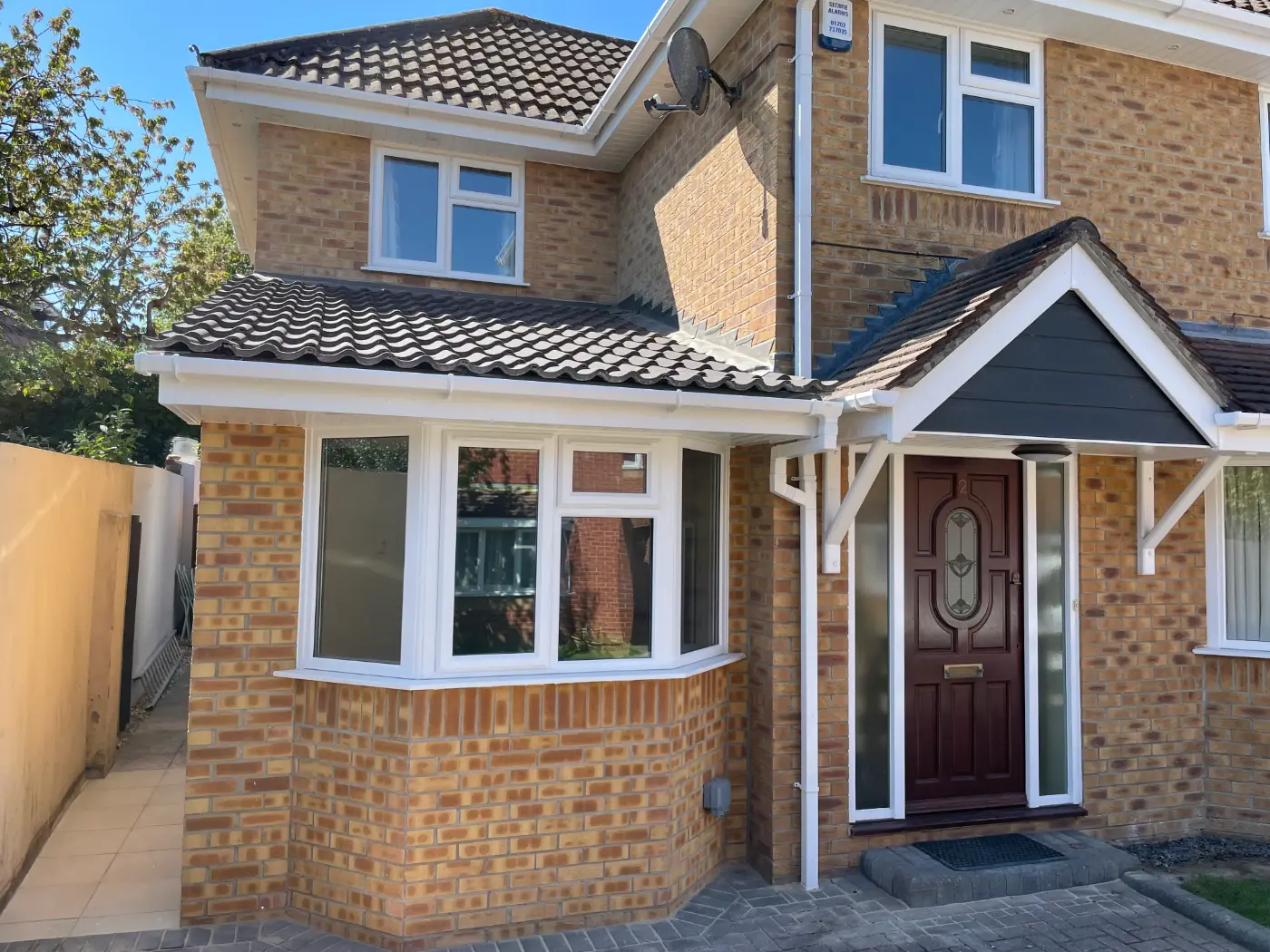 Brick side extension with a new bay window and tiled roof, matched to the existing house