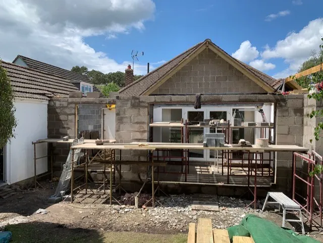 The rear extension under construction, with new blockwork walls built out from the back of the house and scaffolding along the new wall
